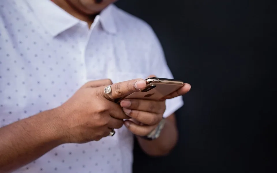Hände halten ein Smartphone und tippen auf dem Display