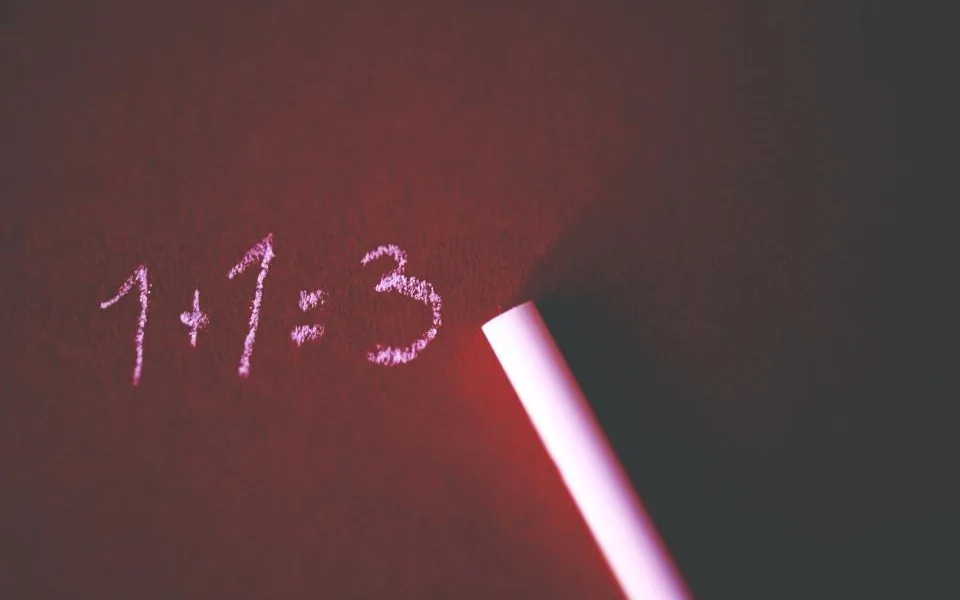 Mit Kreide auf eine dunkle Tafel geschriebene Rechnung 1+1=3