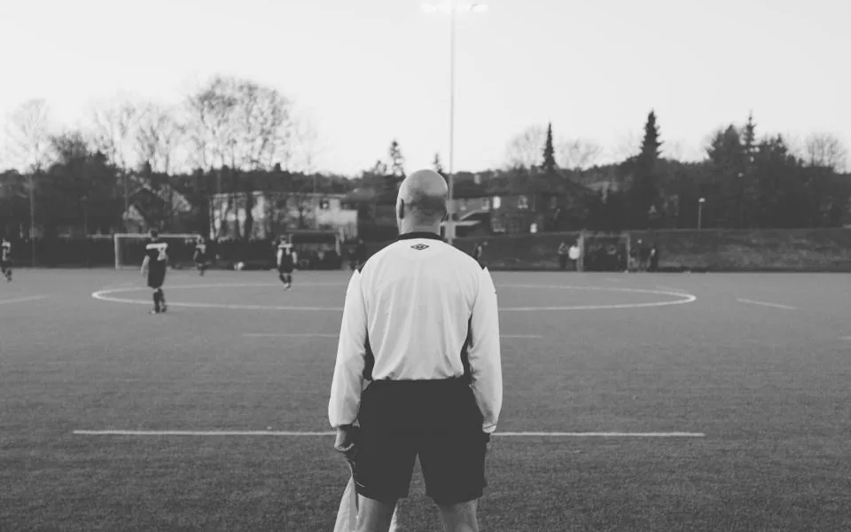 Schiedsrichter von hinten auf einem Fußballplatz, Schwarzweißaufnahme